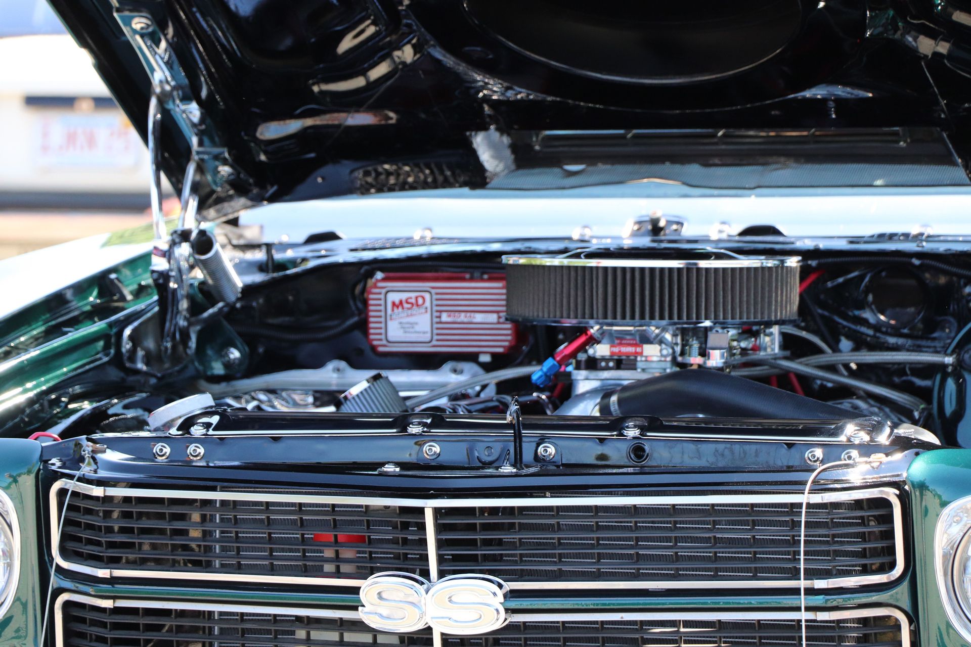 Detailed view of a classic car's engine displayed with the hood open, showcasing mechanics.